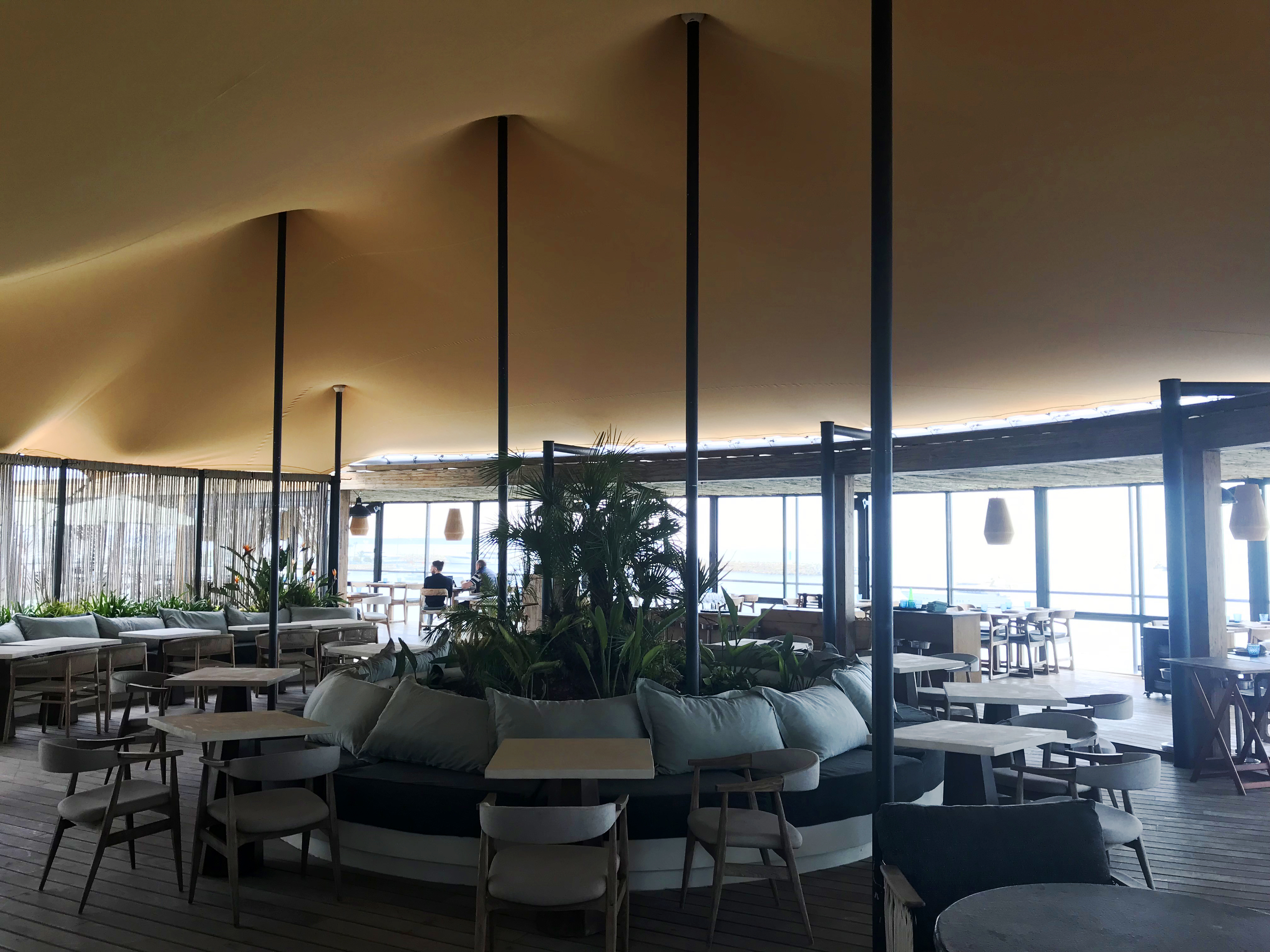 Toile stretch sable au-dessus de la salle d’un beach club ouvert sur la mer